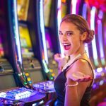 Young happy woman at a casino playing with slot machines